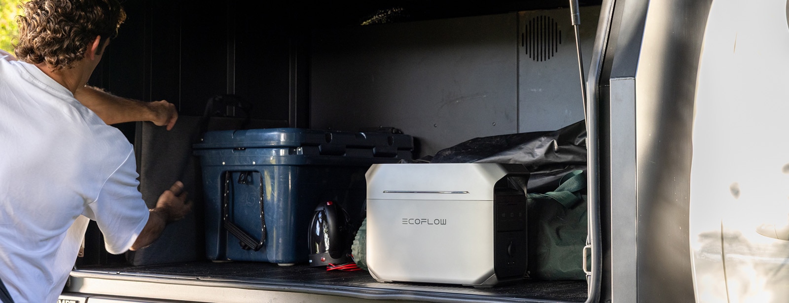 Man in white shirt unpacking camping gear
