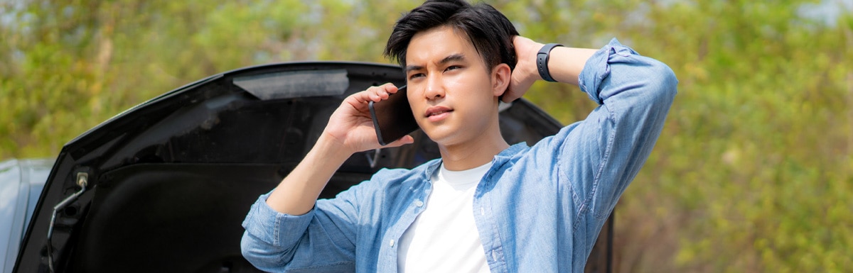 Man looking upder the bonet of his car